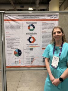 Carrie Milliard in front of her poster at AAIC.